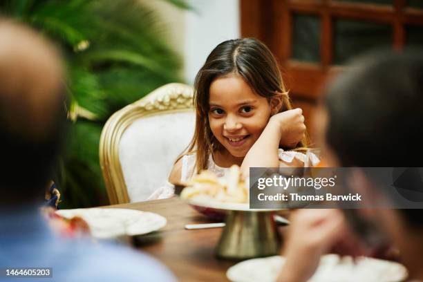 medium close up shot of young girl at dining room table during dinner - cute arab girls stock-fotos und bilder