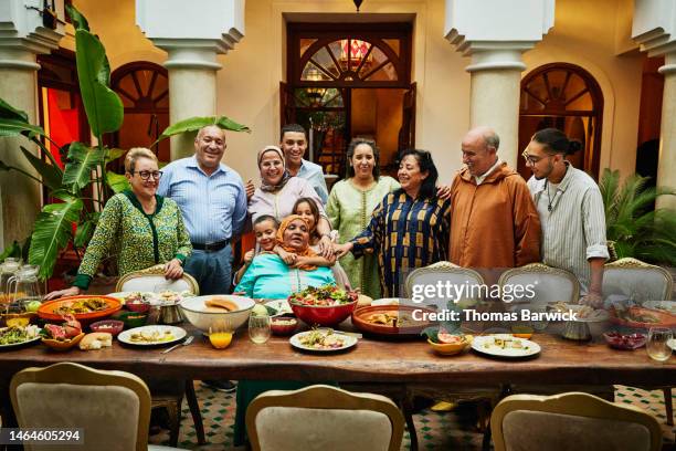 wide shot of multigenerational family gathered for celebration dinner - wealthy family inside home stock pictures, royalty-free photos & images