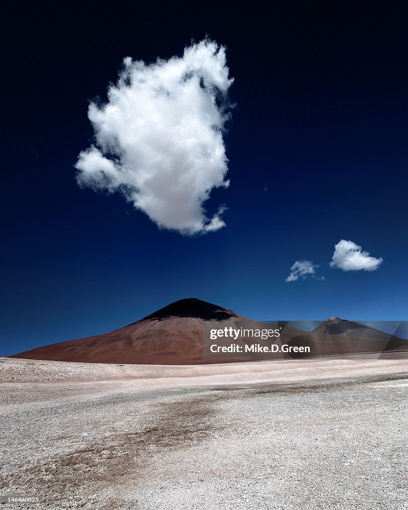 Twin volcanoes by clouds in Altiplano