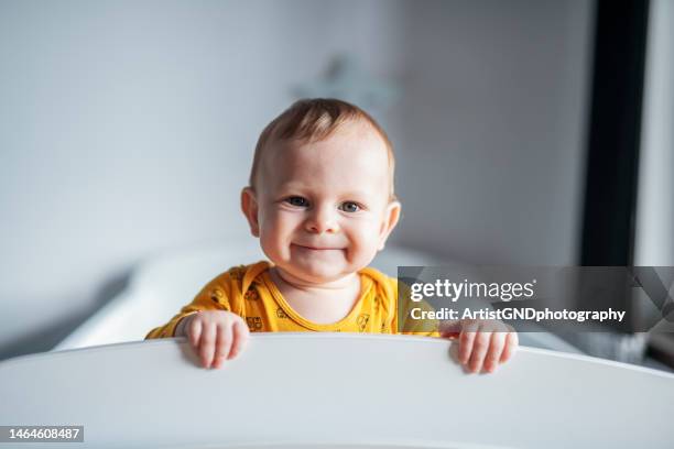 porträt eines süßen kleinen jungen, der durch seine krippe späht. - babypause stock-fotos und bilder