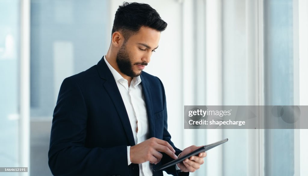 Window, tablet and business man typing, research or social media online in office workplace. Technology, app and male employee holding digital touchscreen for internet browsing or web scrolling.