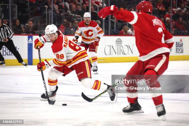 Andrew Mangiapane of the Calgary Flames tries to control the puck behind Olli Maatta of the Detroit Red Wings during the first period at Little...