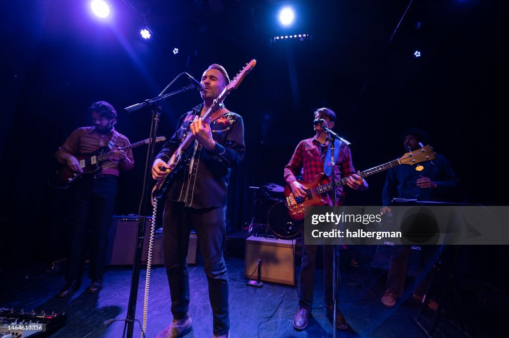 Singer Closing his Eyes While Performing Onstage with Band