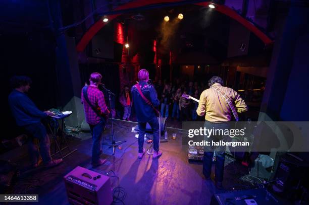 view of band performing to audience from back of stage - modern rock stock pictures, royalty-free photos & images