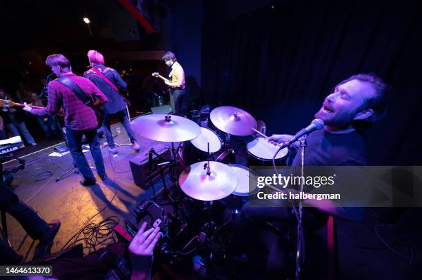 drummer singing backup vocals with band onstage - popular music concert imagens e fotografias de stock