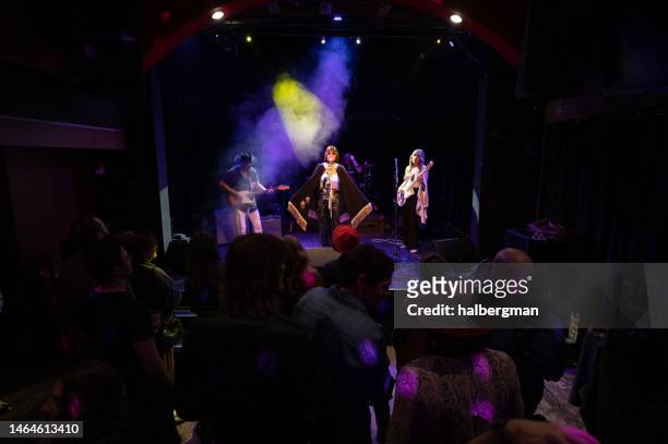 singer wearing cape performing on stage with band - american concerts stock pictures, royalty-free photos & images