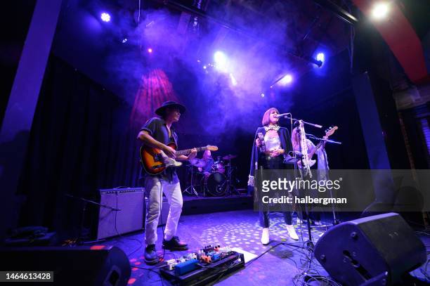 band performing onstage at small venue - modern rock stock pictures, royalty-free photos & images