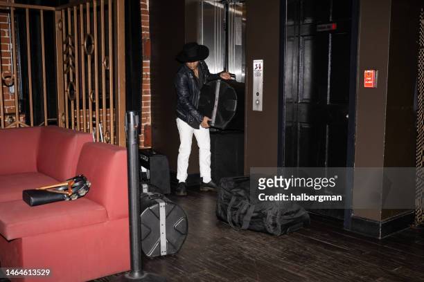 musician bringing drums into concert venue through elevator - roadie stock pictures, royalty-free photos & images