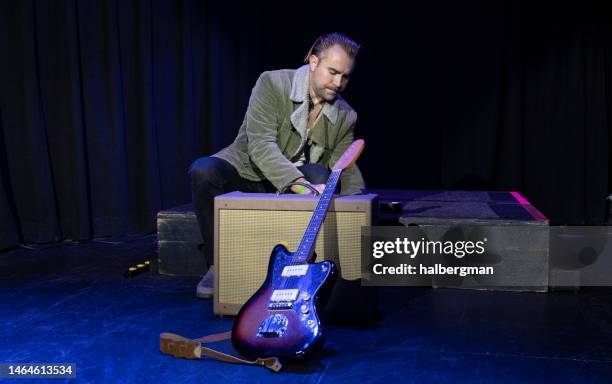 guitarist setting up guitar and amp on stage - roadie stock pictures, royalty-free photos & images