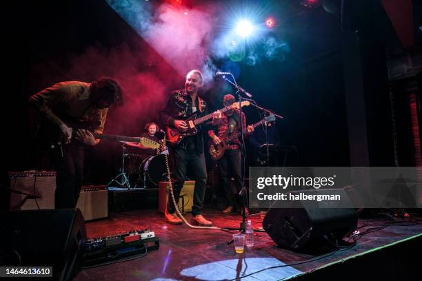 grinning musicians performing on stage - rock group stock pictures, royalty-free photos & images