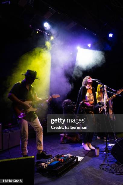 female fronted rock band performing live on stage - rock music concert stock pictures, royalty-free photos & images