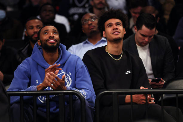 New Nets players Mikal Bridges and Cam Johnson watch from the crowd after being traded for Kevin Durant during the game against the Chicago Bulls at...