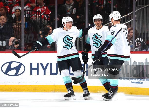 Adam Larsson of the Seattle Kraken is congratulated by teammates Ryan Donato and Alex Wennberg after Larsson scored during the second period against...