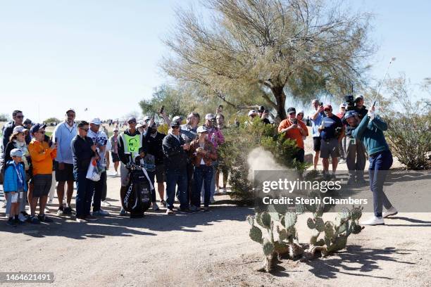 Sam Ryder of the United States plays a shot from the rough on the ninth hole as fans look on during the first round of the WM Phoenix Open at TPC...