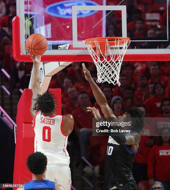 Marcus Sasser of the Houston Cougars shoots against Tim Dalger of the Tulsa Golden Hurricane during the first half at Fertitta Center on February 08,...