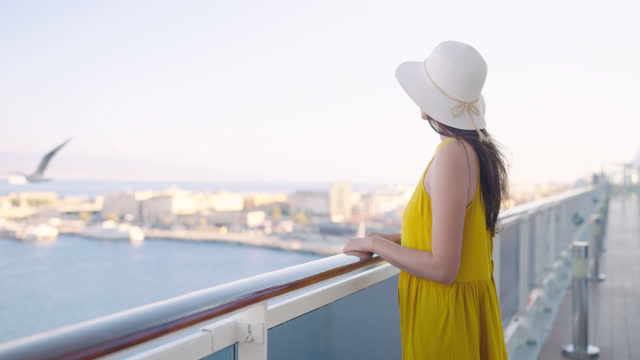 Luxury cruise ship with elegant woman watching sunset on outdoor deck balcony. Cruising vacation.