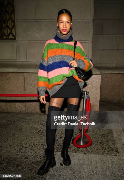Model is seen wearing a striped sweater, black skirt, black thigh high socks, black boots and black bag outside the Christian Siriano show during New...