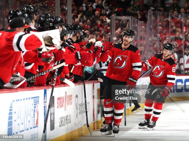 Dougie Hamilton of the New Jersey Devils is congratulated by teammates on the bench after he scored during the third period against the Seattle...