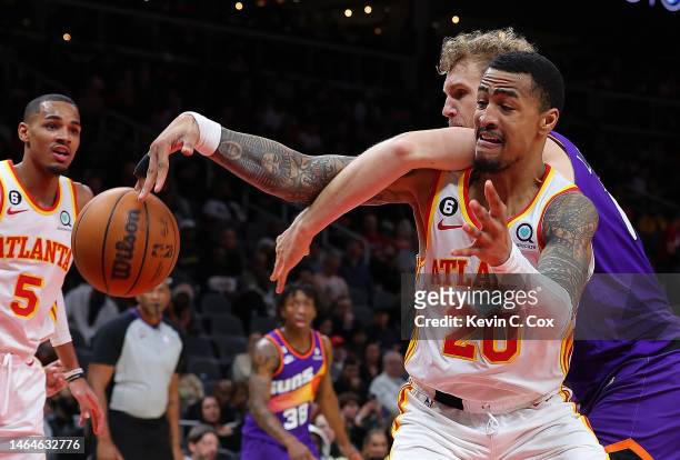 John Collins of the Atlanta Hawks battles for a rebound against Jock Landale of the Phoenix Suns during the fourth quarter at State Farm Arena on...