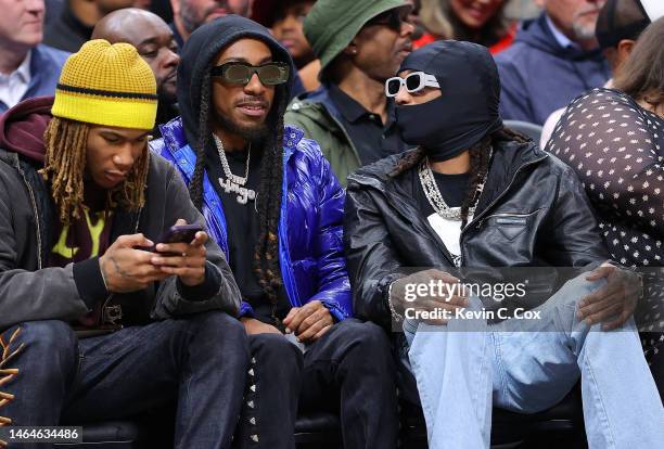 Recording artist Quavo and artist YRN Lingo look on during the second quarter between the Atlanta Hawks and the Phoenix Suns at State Farm Arena on...