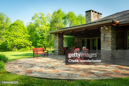 Man reading outside in red chair at home