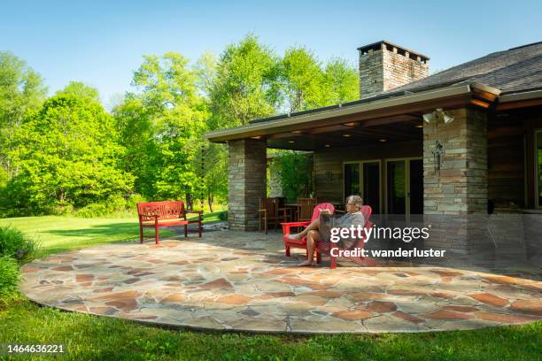 man reading outside in red chair at home - outdoor guy sitting on a rock stock pictures, royalty-free photos & images