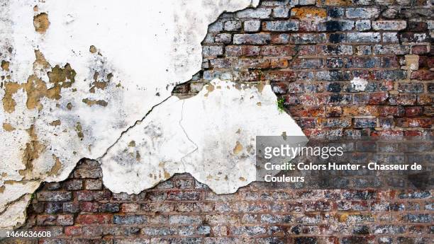 very old weathered and damaged brick and stucco wall painted white in london - plastering stock pictures, royalty-free photos & images