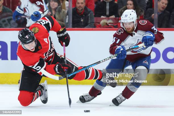 Connor Murphy of the Chicago Blackhawks and J.T. Compher of the Colorado Avalanche battle for control of the puck during the first period at United...
