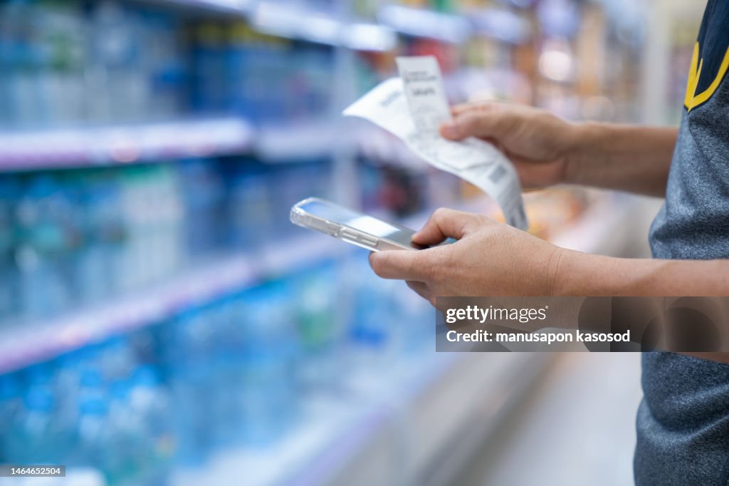 Man checking bill in supermarket.