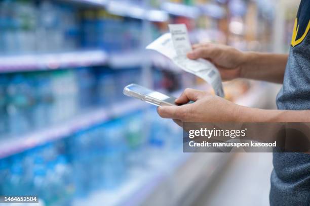 man checking bill in supermarket. - expense receipts stock pictures, royalty-free photos & images