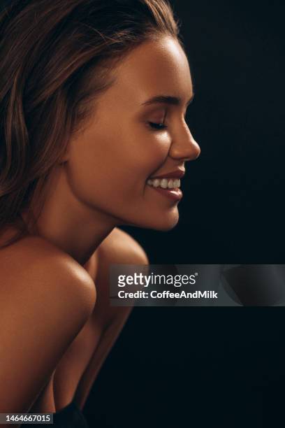 schöne emotionale frau mit natürlichem make-up - lady face black background happy stock-fotos und bilder
