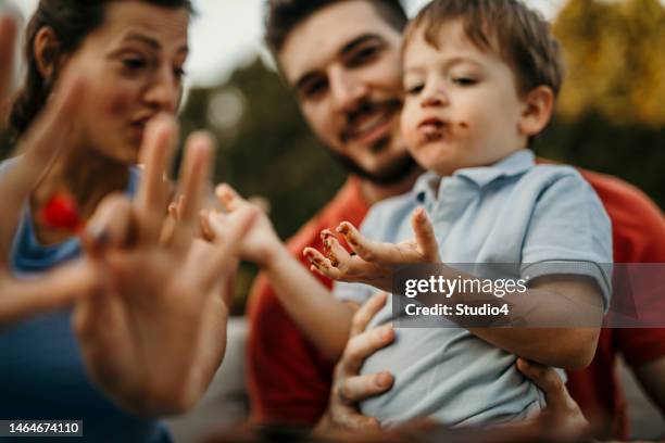 candid portrait of a toddler boy eating chocolate cake. happy childhood concept - cake smashing stock pictures, royalty-free photos & images