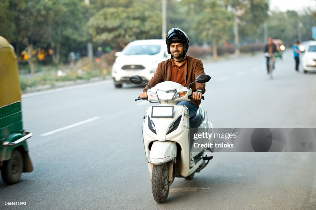 Homem que monta a motocicleta com capacete