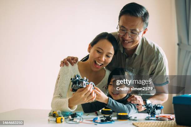 home engineering: asian family's collaborative robot build - school science project stock pictures, royalty-free photos & images