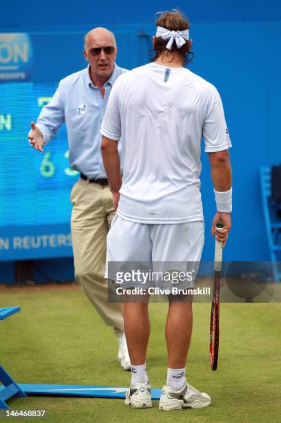 David Nalbandian of Argentina looks on at the Line Umpire after injuring his leg during his mens singles final round match against Marin Cilic of...