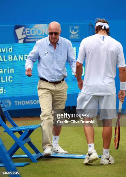 David Nalbandian of Argentina speaks with the Line judge after injuring his leg during his mens singles final round match against Marin Cilic of...