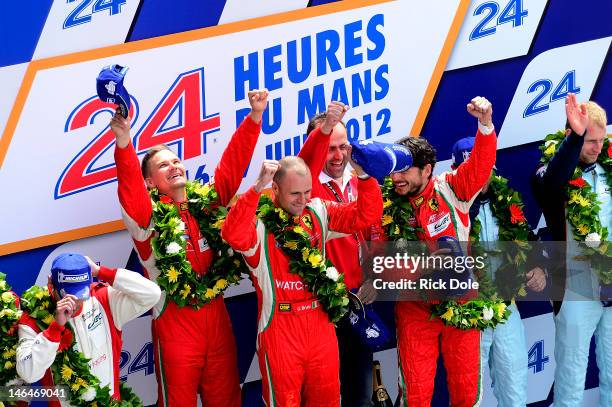 Giancarlo Fisichella of Italy, Gianmaria Bruni of Italy, and Toni Vilander of Finland celebrate on the podium after claiming GT class victory in...