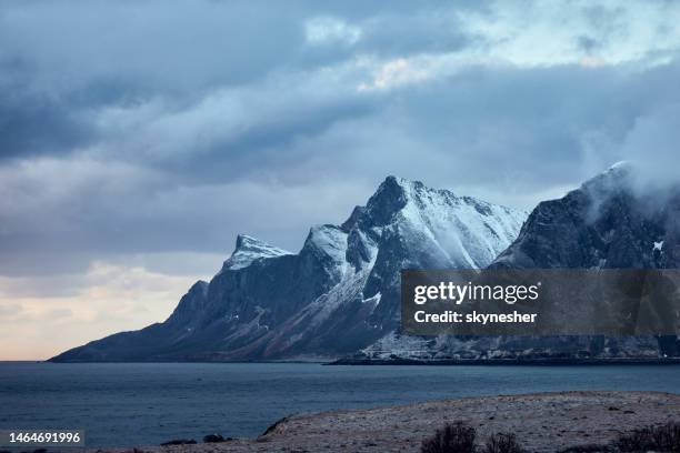 snowcapped mountain range in lofoten, norway. - lofoten stock pictures, royalty-free photos & images