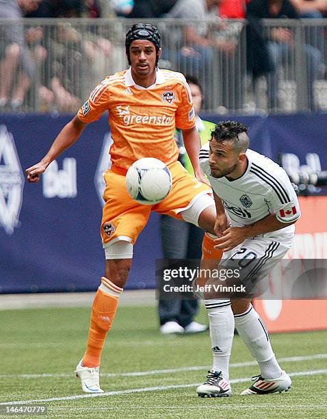 Davide Chiumiento of the Vancouver Whitecaps FC and Calen Carr of the Houston Dynamo battle for the ball during their MLS game at BC Place June 10,...