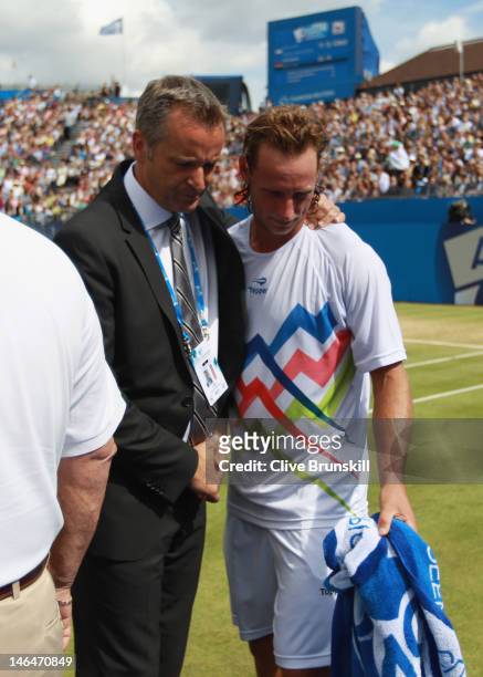 David Nalbandian of Argentina shows his dejection as he is consoled by Tournament Director Chris Kermode after learning of his disqualification for...