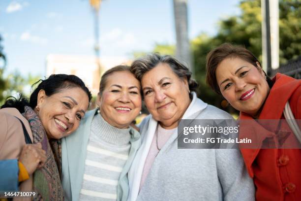 retrato de amigos mayores abrazados al aire libre - mujeres mexicanas fotografías e imágenes de stock