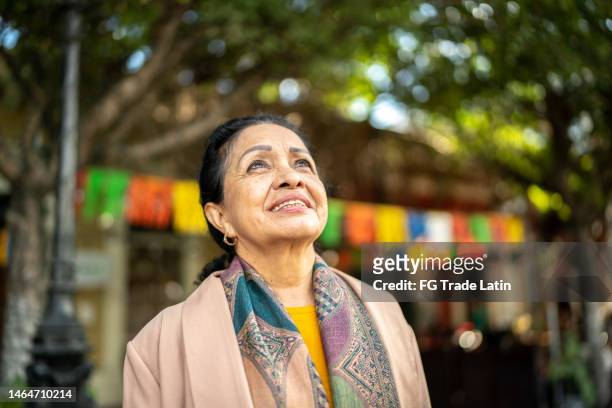 senior woman looking away contemplating outdoors - black hair stock pictures, royalty-free photos & images