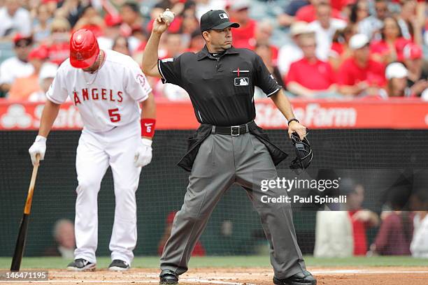 Home plate umpire Angel Campos throws the ball back to the pitcher during the game against the Baltimore Orioles on April 22, 2012 at Angel Stadium...