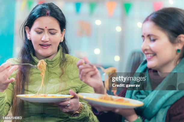 two women enjoy chinees veg noodles at home. - chinees stock pictures, royalty-free photos & images