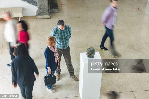 overhead view of busy museum lobby packed with visitors - museum pedestal stock pictures, royalty-free photos & images