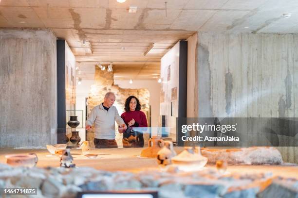 un couple diversifié senior visitant une exposition sur les cultures anciennes dans le musée de l’histoire - musée historique photos et images de collection