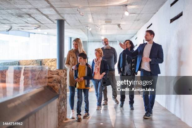 eine gruppe verschiedener museumsbesucher, die ihrem führer zuhören und ihnen eine tour im historischen museum geben - museumswärter stock-fotos und bilder