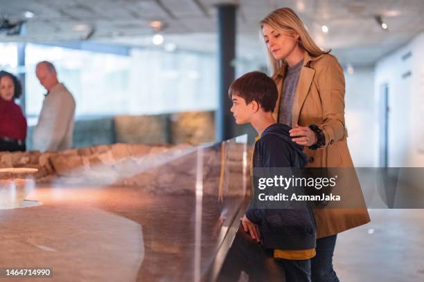 a caucasian mother visiting a museum with a caucasian young son on a weekend - history museum stock pictures, royalty-free photos & images