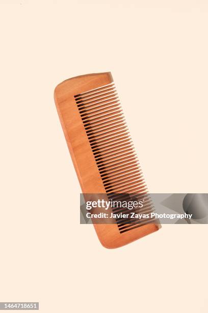 wooden comb on beige background - kammen stockfoto's en -beelden