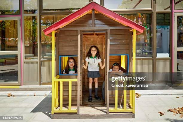 spielhausporträt von grundschulmädchen - spielzeughaus stock-fotos und bilder